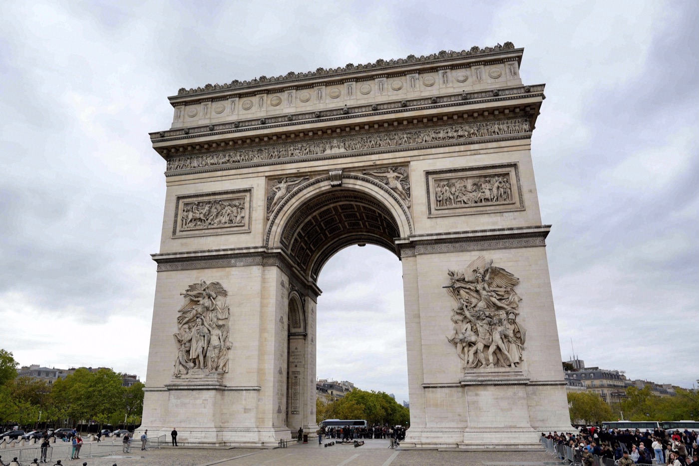 Nahaufnahme des Arc de Triomphe mit den detailreichen Reliefs an den Pfeilern, aufgenommen bei bewölktem