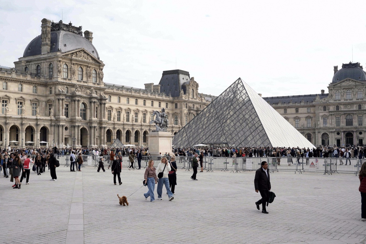Die gläserne Eingangspyramide des Louvre überragt die Cour Napoléon, umgeben von Besuchermassen und dem